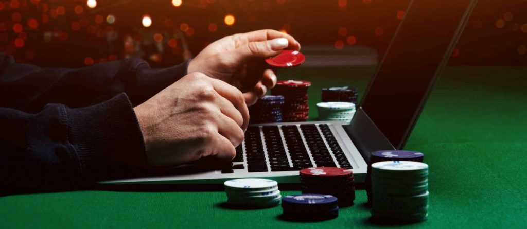 online-casino-man-hands-on-laptop-with-chips